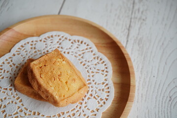 素朴な木の皿に置かれた、ナッツの香ばしさが漂うサクサクとした食感のクッキー、癒しのひとときを演出