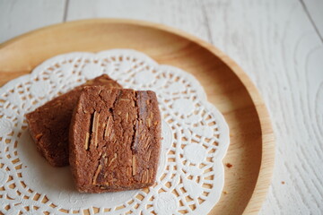 木のプレートに並べられた、チョコレートとココナッツの風味が豊かな、深い色合いが魅力的なクッキー