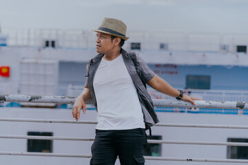 Asian man in backpack standing on the ship enjoy solo traveling a beautiful view on the ocean....