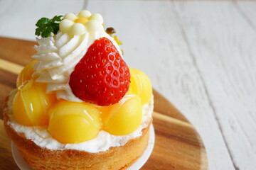 色鮮やかなフルーツタルトのクローズアップ、ジューシーなイチゴと黄色い実が輝くデザート