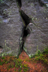Natural rock formation with deep crevice and moss