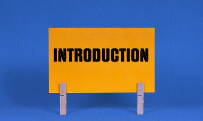 INTRODUCTION Symbol. Concept words INTRODUCTION on Yellow Rectangle Paper Held by Wooden Clothespin...