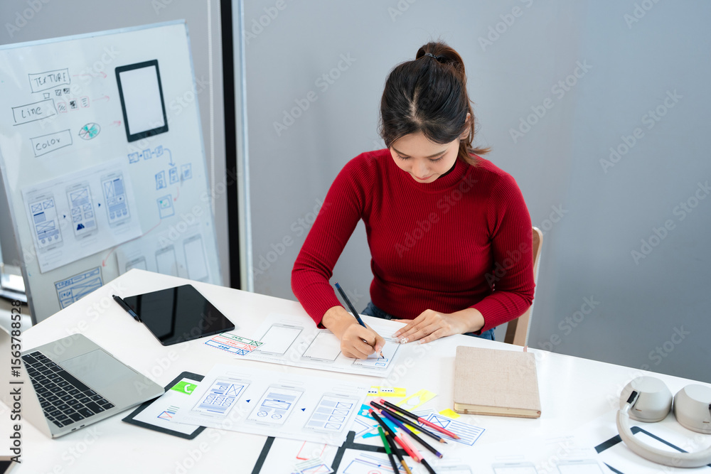 Fototapete Website development UI UX front end designer sketching wireframe layout design mockup for responsive web content in bright modern office.