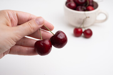 Fresh cherries in a ceramic cup on the table. A handful of delicious berries. Antioxidants and...