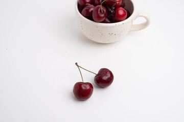 Fresh cherries in a ceramic cup on the table. A handful of delicious berries. Antioxidants and vitamins