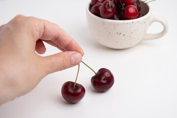 Fresh cherries in a ceramic cup on the table. A handful of delicious berries. Antioxidants and vitamins