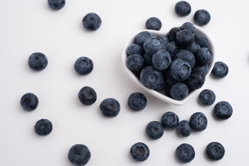 Fresh organic blueberries in a plate on a light background. Antioxidants and vitamins