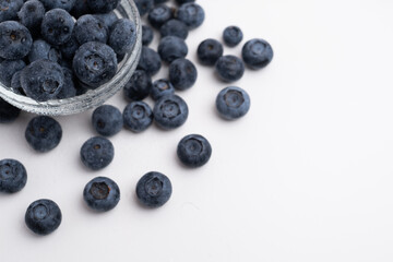 Fresh organic blueberries in a plate on a light background. Antioxidants and vitamins