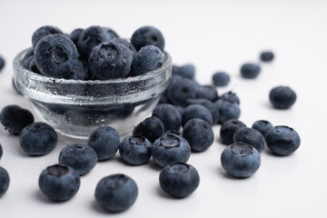 Fresh organic blueberries in a plate on a light background. Antioxidants and vitamins