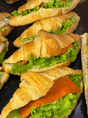 Freshly made croissant sandwiches with lettuce and salmon. Ideal image for café menus, breakfast, or healthy snack themes