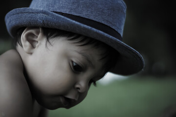 Close up of a Mexican baby boy wearing a blue hat