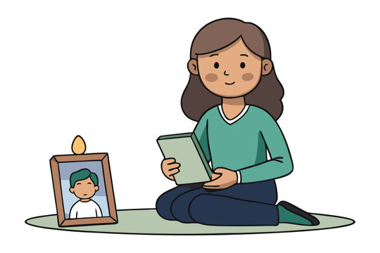 A person sits on a mat holding a book remembering a loved one with a framed photo and a lit candle nearby