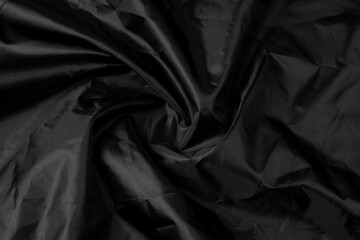 Black background texture. Black colored wavy fabric.