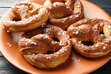 Tasty pretzels with salt on table, closeup