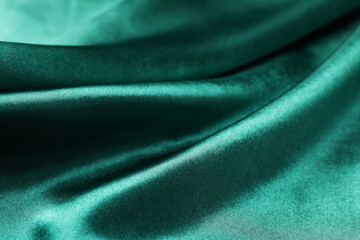 Crumpled green silk fabric as background, closeup