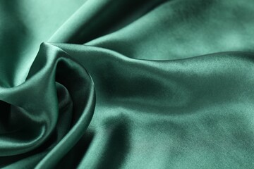 Crumpled green silk fabric as background, closeup