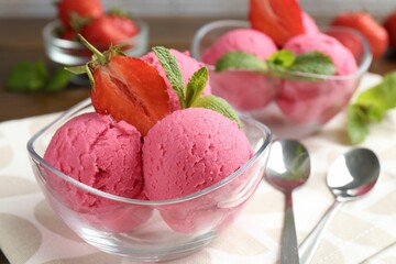 Tasty sorbet with strawberries and mint served on wooden table, closeup