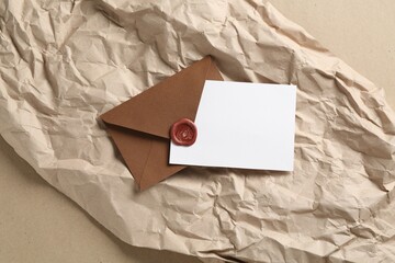 Blank invitation card, envelope and parchment paper on carton, top view. Space for design