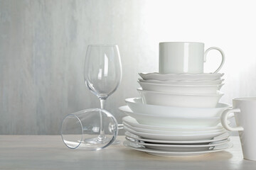 Different clean dishware on light wooden table indoors