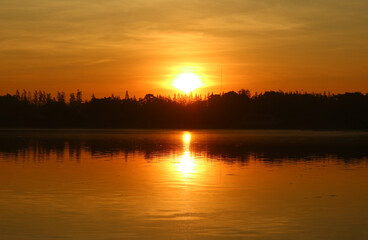 Stunning Bright Sun Rising on Golden Sky over the Lake