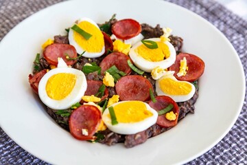 Traditional black bean tutu with kale, calabrese sausage, bacon and egg. A classic rustic dish from Minas Gerais