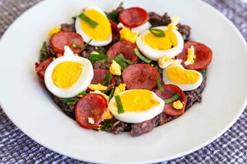 Traditional black bean tutu with kale, calabrese sausage, bacon and egg. A classic rustic dish from Minas Gerais