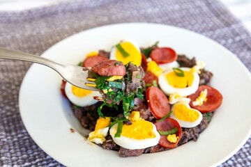 Traditional black bean tutu with kale, calabrese sausage, bacon and egg. A classic rustic dish from Minas Gerais