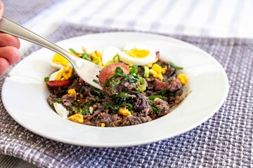 Traditional black bean tutu with kale, calabrese sausage, bacon and egg. A classic rustic dish from Minas Gerais