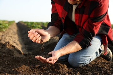 Man with pile of soil in field, closeup