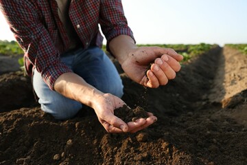 Man with pile of soil in field, closeup