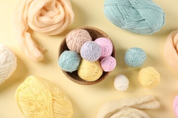 Felting wool and knitting yarn on beige background, flat lay