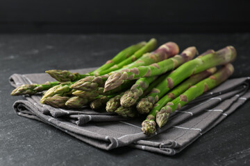 Fresh raw asparagus spears on black table, closeup