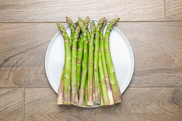 Fresh raw asparagus on wooden table, top view