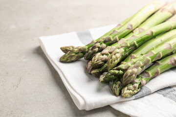 Fresh raw asparagus on light grey table, closeup. Space for text