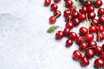 Fresh ripe cherries on light table, flat lay. Space for text