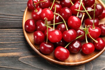 Fresh ripe cherries on black wooden table, closeup