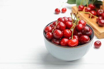 Fresh ripe cherries on white wooden table, closeup. Space for text