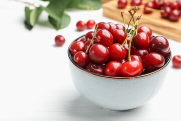 Fresh ripe cherries on white wooden table, closeup. Space for text