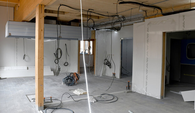 chantier de construction int&eacute;rieur, avec cables pendant du plafond, murs non termin&eacute;s, chantier en cours