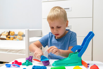 Child boy playing,molding plasticine.Kid sculpts with clay stucco.Play dough.art creativity,craft...