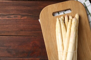 Raw asparagus spears on wooden table, top view. Space for text