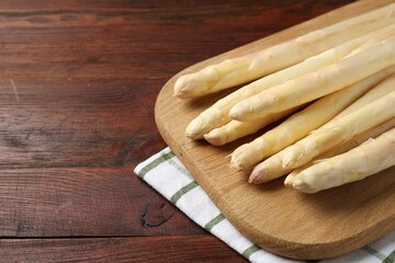 Raw asparagus spears on wooden table, closeup. Space for text
