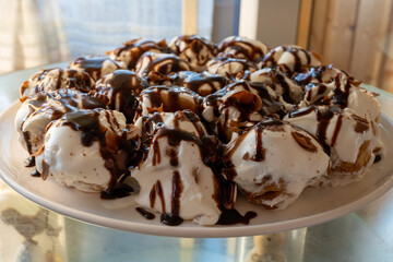 Delicious profiteroles with creamy filling and chocolate glaze, classic French dessert pastry...