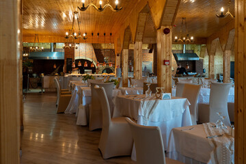Interior of Romanian restaurant with wooden decorations and set tables creating warm and inviting dining atmosphere
