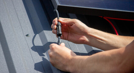 Technician Installing Solar Panels on Metal Roof