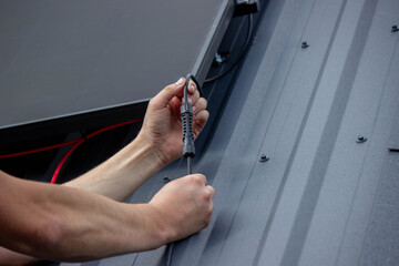 Technician Installing Solar Panels on Metal Roof