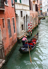 Gondolier with a hat on head and striped shirt in white and red while rowing the gondola boat Venice in Italy © ChiccoDodiFC
