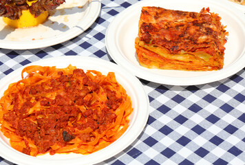 fresh egg pasta dish called TAGLIATELLE in Italian with meat and tomato sauce and a plate of...