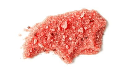 Close up of a delicious looking textured piece of pink confectionery with small dark seeds on a white surface