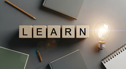 Wooden blocks spelling learn with a lit lightbulb and stationery learning education